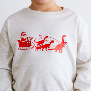 Sweet Wink Dino Christmas Long Sleeve Shirt - Natural
White sweatshirt with red Santa Claus and reindeer design on a white background