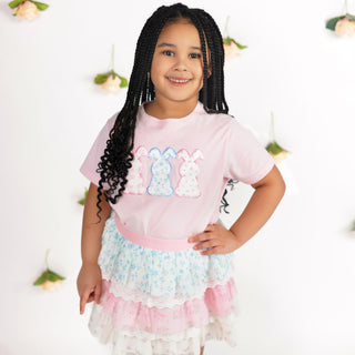 Sweet Wink Floral Bunny Patch Easter Short Sleeve T-Shirt - Ballet
Young girl wearing a pink shirt with colorful designs and a white skirt with ruffles.