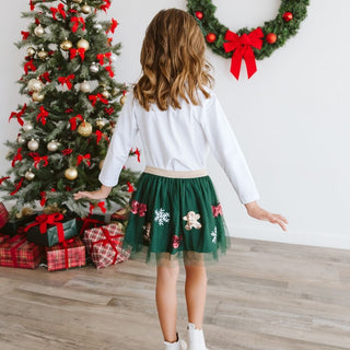 Sweet Wink Gingerbread Joy Sequin Christmas Tutu
Child in a green skirt with Christmas decorations in the background