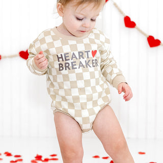 Sweet Wink Heartbreaker Checkered Valentine's Day Long Sleeve Romper - Natural
Child wearing a 'Heart Breaker' onesie with a checkered pattern, standing against a white background with red heart decorations.