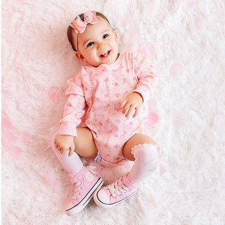 Sweet Wink Pink Rose Long Sleeve Romper - Pink
Baby wearing a pink outfit with floral patterns on a soft white background