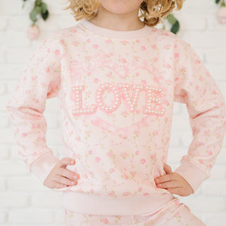 Sweet Wink Pink Rose Love Patch Sweatshirt - Pink
Child wearing a pink floral sweatshirt with 'LOVE' text on a light background
