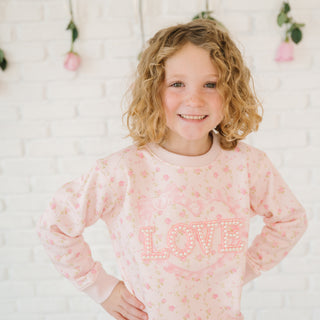 Sweet Wink Pink Rose Love Patch Sweatshirt - Pink
Young girl wearing a pink 'LOVE' sweatshirt with floral patterns against a white background.