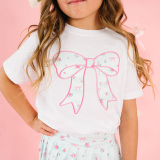 Sweet Wink Sky Blue Floral Bow Patch Short Sleeve T-Shirt - White
Child wearing a white t-shirt with a pink bow design on a pink background