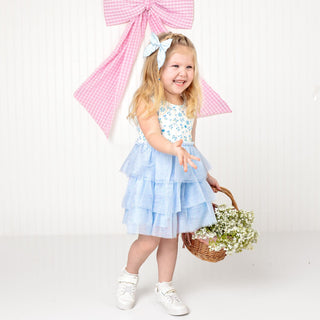 Sweet Wink Sky Floral Tank Tutu Dress
Young girl in a light blue dress with a pink bow in the background