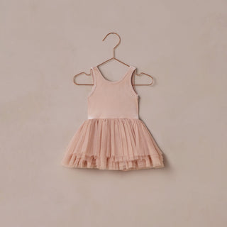 Noralee Tallulah Tutu - Rose
Pink dress with a tutu skirt on a hanger against a beige wall