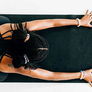 Teleties  Eat Glitter for Breakfast Hair Ties - Large
Person with braided hair and colorful beads lying on a black mat