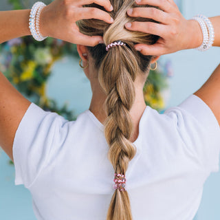 Teleties Pretty in Pink Hair Ties - Tiny Person with a braided hairstyle featuring hair ties against a blurred natural background