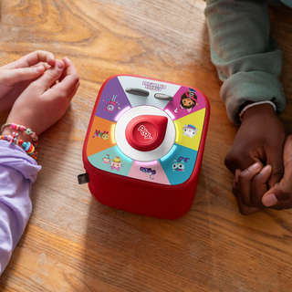 Tonieplay Gabby's Dollhouse: Gabby's Cat-tastic Scavenger Hunt Game
Colorful toy with cartoon characters on a wooden table, surrounded by children's hands.