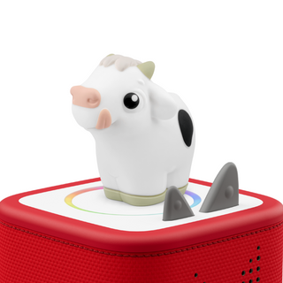Toy cow on a red base with a white background
