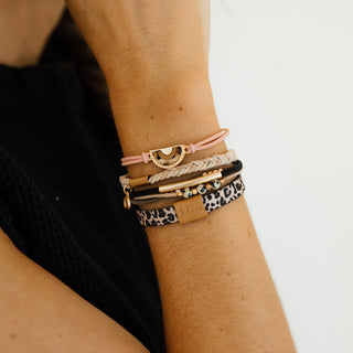 K'lani "Wild" Animal Print with Pink Accent Hair Tie Bracelets
Close-up of a wrist wearing multiple bracelets on a plain background