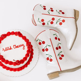Wild & Rae Cowgirl Boots - Wild Cherry
White boots with cherry design and a cake with 'Wild Cherry' text on a white background