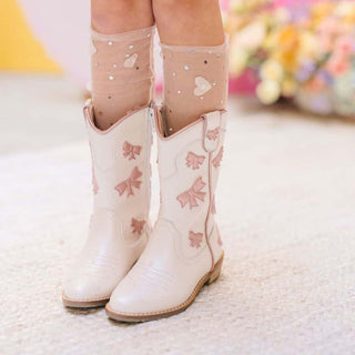 Wild & Rae cowgirl boots in white leather with pink bows, featuring a stylish Western design and pointed toe.