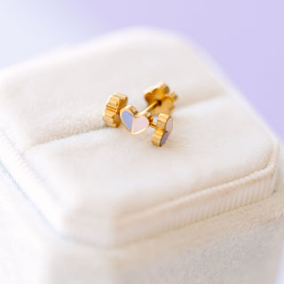 Pierced Co. Micro Heart Duo Earrings
Gold stud earrings with heart-shaped stones on a white cushion