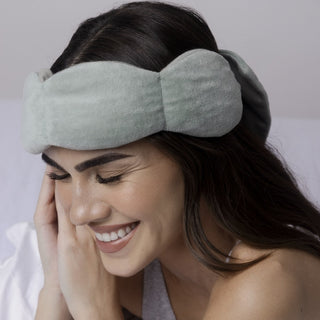Noppod Weighted Sleep Eye Mask - Sage
Woman wearing a gray sleep mask with a plain background