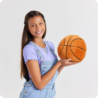 Basketball Warmies
Young girl holding a plush basketball against a light gray background