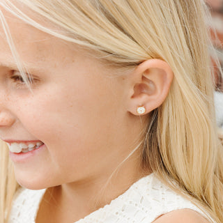 Pip Pop Post Earrings - White Cat
Close-up of a young girl wearing a diamond earring.