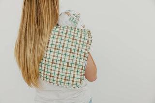 Copper Pearl Grayson Burp Cloth Set
Person wearing a green and brown checkered apron on a plain background