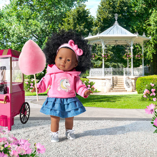 Corolle Maelys 14" Doll
Doll in a pink hoodie and blue skirt holding pink cotton candy in a park setting with a gazebo.