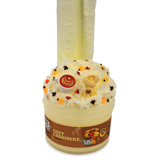 Peachybbies Cloud Slime - Cozy Cashmere
A novelty cup-shaped product labeled 'COZY CASHMERE' filled with pale cream-colored material, topped with faux whipped cream, small decorative sprinkles, and two vertical fluffy inserts, shown on a plain white background.
