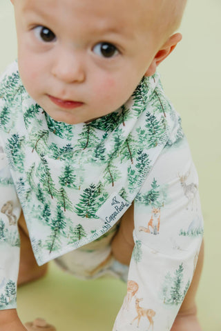 Copper Pearl Grayson Bandana Bib Set
Baby wearing a bib with forest design and animal illustrations on a light green background