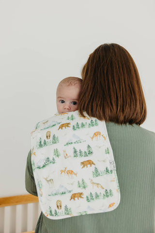 Copper Pearl Grayson Burp Cloth Set
Woman holding a baby wrapped in a blanket with forest animal pattern