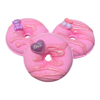 The Lavish Goat Donut Prize Bath Bomb - Pink Sugar
Three pink donut-shaped bath bombs with decorative elements on a white background