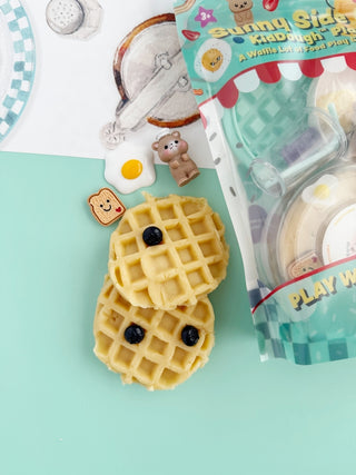 Earth Grown KidDough EGKD Sunny Side Diner KidDough Play Kit
Waffle-shaped toy with a sunny side up egg and blackberries on a light blue background, with packaging in the corner.