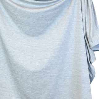 Lou Lou and Company Swaddle Blanket - Crew
A close-up of a light heather gray t-shirt with draped, flowing fabric and a short sleeve visible on the right side, set against a plain white background.