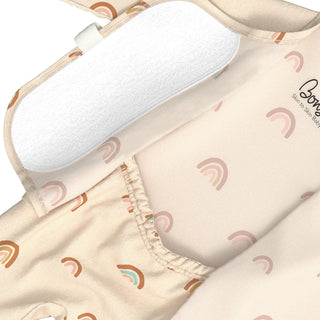 Bonsie Footie - Little Wishes
Close-up of a baby romper or bodysuit with a soft white insert pad on the chest, featuring a light beige fabric printed with pastel rainbow motifs. The brand name 'Bong' is visible on the side.