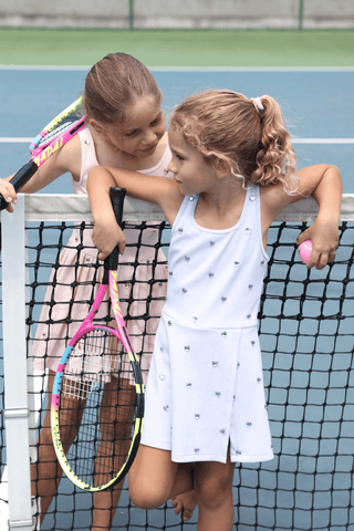 Lavender Lola & The Boys Heart Scuba Tennis Dress displayed on a hanger, showcasing its vibrant color and stylish design.
