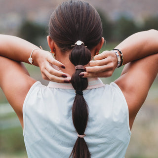 K'lani "Drive" Black & Cream Hair Tie Bracelets with Removable Ball Marker
Person with a ponytail wearing a light blue sleeveless top outdoors