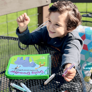 Daily Doodler Reusable Activity Book - Animals Cover
Child holding a green art set with markers outdoors