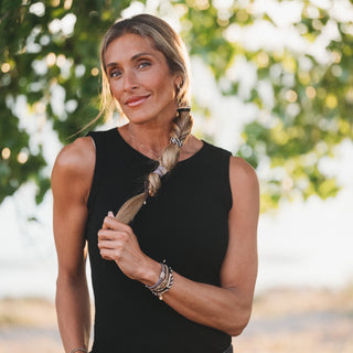 K'lani "Ember" with Tortoise Shell Ring Charm Hair Tie Bracelets
Woman with braided hair wearing a black sleeveless top outdoors
