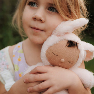Olli Ella Cozy Dinkums - Bunny Pip
Young girl holding a plush toy with bunny ears outdoors