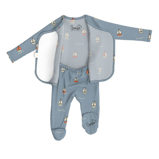 Bonsie Footie - Ahoy Baby
A baby footed one-piece outfit in dusty blue with a sailboat pattern, shown open to reveal a white fleece lining. The long-sleeve top and matching footed pants are decorated with small sailboats, wavy lines, and the brand name 'Cocoon' printed on the chest and leg.