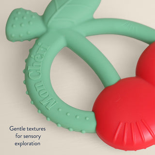 Itzy Ritzy Bitzy Shake silicone teether with cherry design and attached rattle for babies.