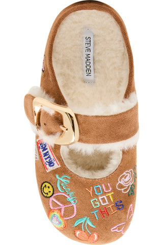 Steve Madden Kid's Faux Fur Nugget - Cognac Multi
A single Steve Madden clog-style slipper in tan suede with a white shearling lining, a gold buckle strap, and colorful embroidered patches and text on the toe, shown on a white background.