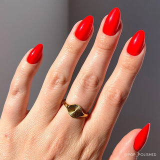 Glamnetic Press-On Nails Short Almond - Fiery Red
Hand with red nails and a gold ring on a gray background