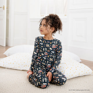 Magnetic Me Harry Potter First Year Modal L/S Pajama Set
Child wearing a navy blue pajama set with vehicle pattern sitting on a bed.