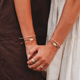 K'lani "Forever Friends" Neutral Sun Friendship Hair Tie Bracelets
Two people holding hands, each wearing delicate gold bracelets with small white bead details and crescent moon charms, styled with a brown top and a white dress.