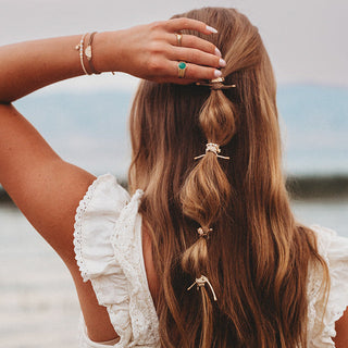 K'lani "Forever Friends" Neutral Sun Friendship Hair Tie Bracelets
Woman with braided hair holding a braid, wearing a white lace top, with a blurred natural background.