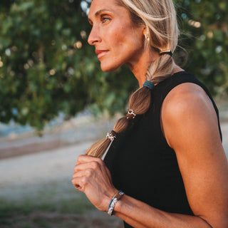 K'lani "Gallop" Horse and Bridle Equestrian Hair Tie Bracelets
Woman with braided hair holding a phone outdoors