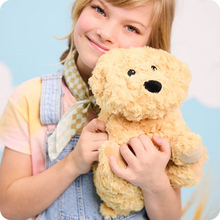 Golden Dog Warmies
Child holding a teddy bear against a light blue background