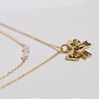 K'lani "Grace" Gold Bow with Pearl Accent Necklace Set
Gold necklace with a star-shaped pendant on a light gray background