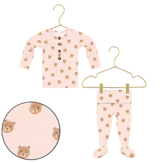 Lou Lou and Company Top and Bottoms - Honey
A baby long-sleeve henley top and matching footed pajama pants in light pink, both printed with a small brown bear face pattern. The top has three brown buttons at the chest.