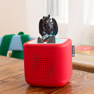 Tonies Character: How to Train Your Dragon: Toothless
Red portable speaker with a dragon figurine on top, placed on a wooden surface.
