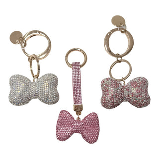 Three bow-shaped keychains with rhinestone embellishments on a white background