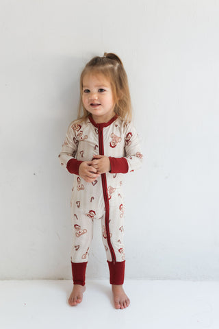 In My Jammers Bear-y Merry Zipper Romper
Child wearing a patterned onesie with red accents on a white background