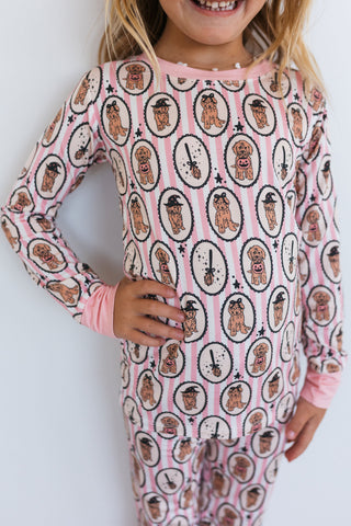 In My Jammers Howl-O-Ween Pups Two Piece Set Child wearing a pink onesie with dog pattern on a white background